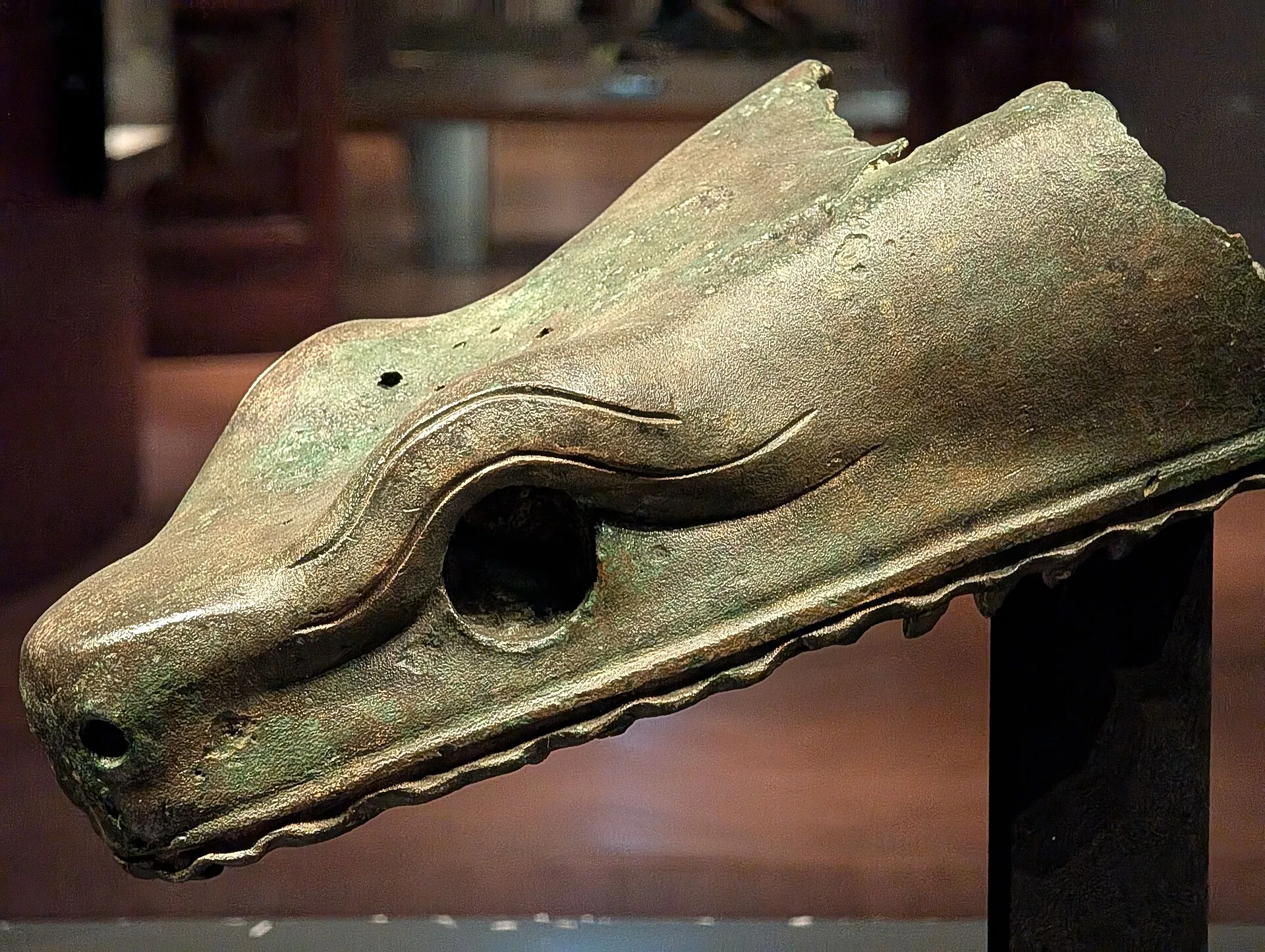 Bronze fragment of the upper jaw of one of the snake heads of the Serpent Column, in a museum case